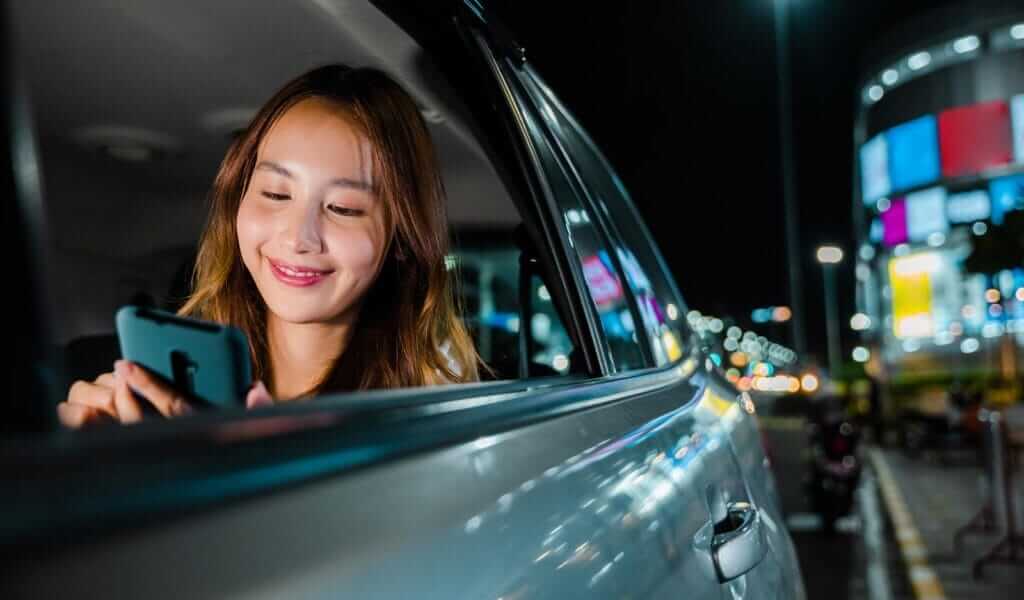 Asian businesswoman commuting from office in Taxi backseat with